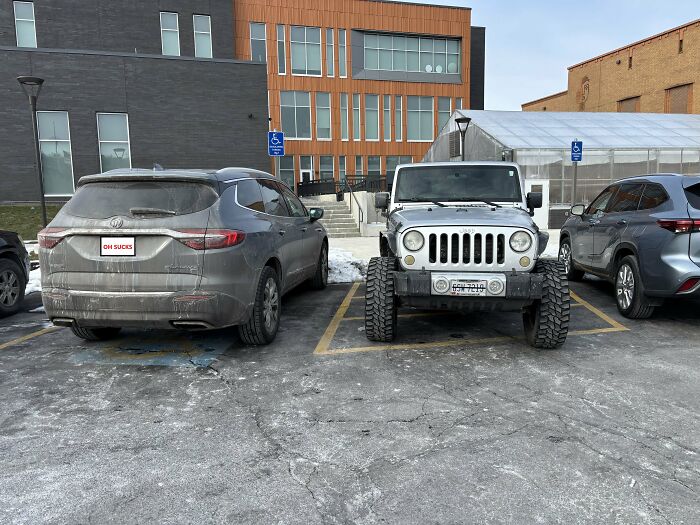 A Jeep poorly parked across multiple handicapped parking spots, highlighting bad parking by neighbors.