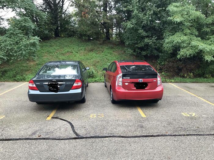 Two cars parked extremely close together, demonstrating poor parking skills and common sense from jerk neighbors.