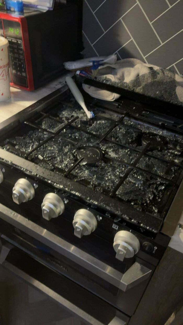 A shattered glass stovetop in a kitchen, indicating a mess that makes becoming a cat lady look attractive.