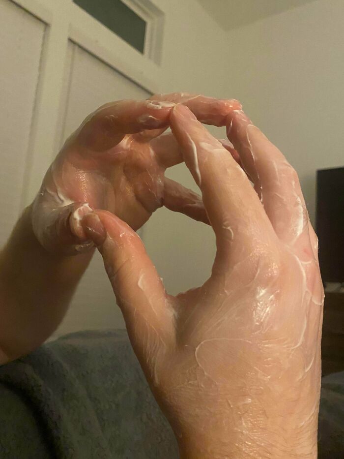 A pair of hands covered in cream, creating a heart shape, illustrating a man in relationships