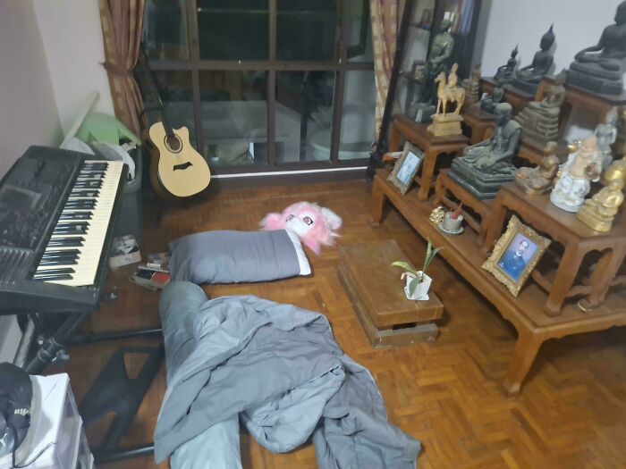 Male living spaces: A messy room with a keyboard, guitar, and various statues, showing how not to live.
