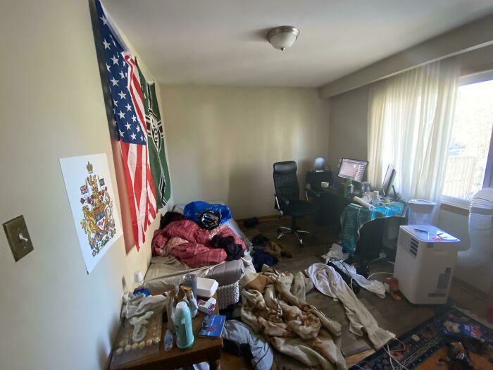A cluttered room with an unmade bed, clothes, and papers, demonstrating an undesirable male living space.