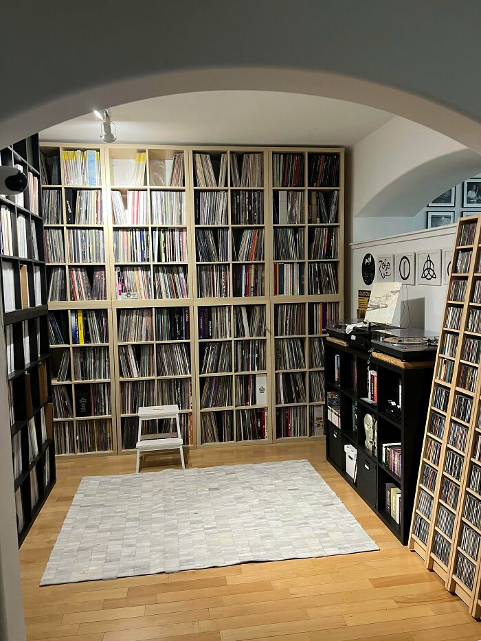 A well-organized male living space with extensive record and CD collections, showcasing a hobby.
