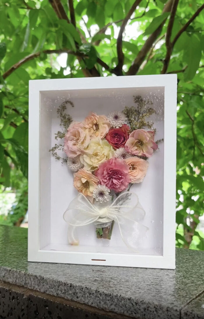 A brilliant DIY home project displaying dried flowers in a white shadow box, perfect for home decor transformation.