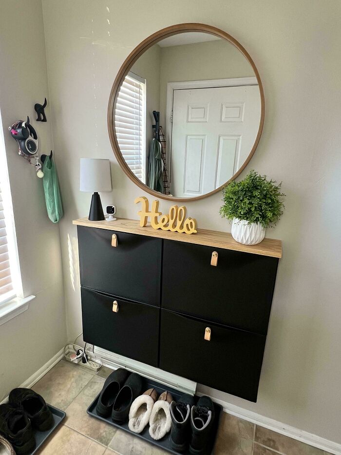 A brilliant DIY home project featuring a sleek black shoe cabinet and round mirror for an organized entryway space.