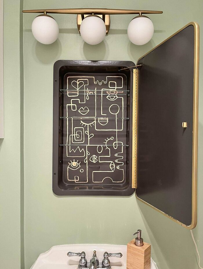 A brilliant DIY home project of a medicine cabinet with an abstract gold design, enhancing a bathroom space.