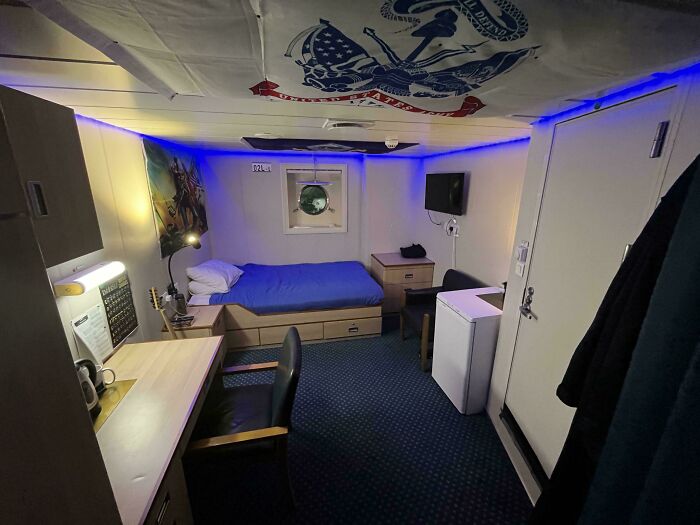 A well-organized male living space with a bed, desk, and blue LED lighting, an inspiration for how to live.