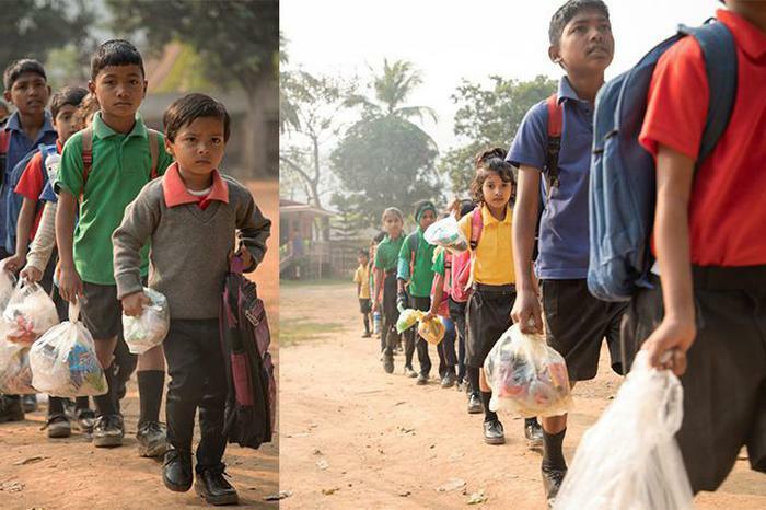 Children carrying bags of trash, symbolizing people making a difference for the world.