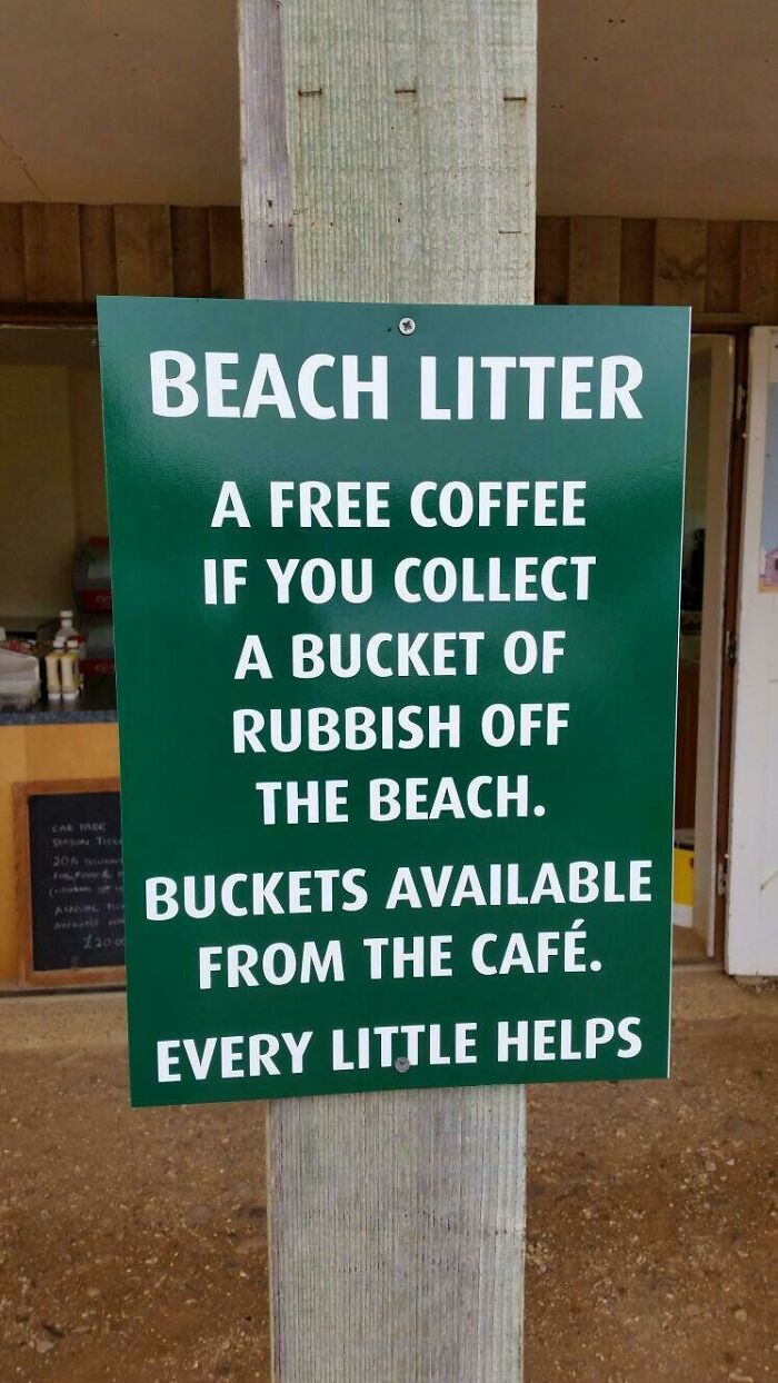 A green sign offering free coffee for collecting a bucket of rubbish from the beach, encouraging people to reduce trash.