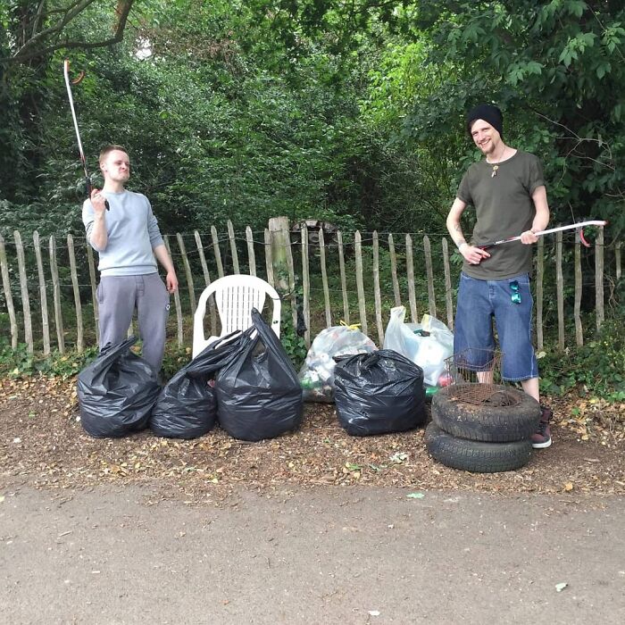 Two young men proud after collecting trash from the forest, becoming influencers for a cleaner world.