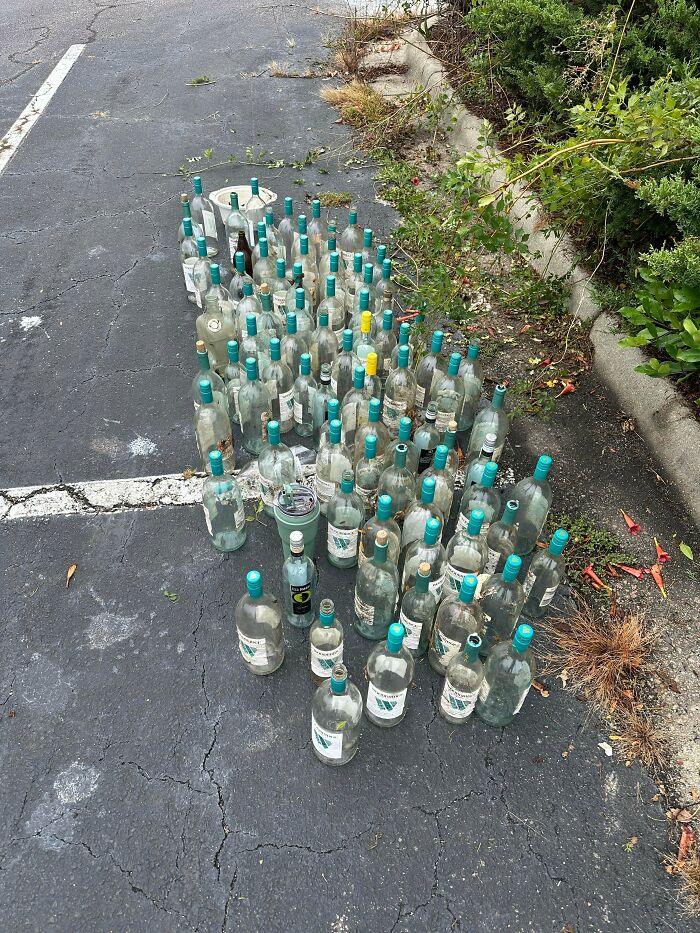 Many empty bottles on an asphalt surface, illustrating the amount of trash that takes over the world.