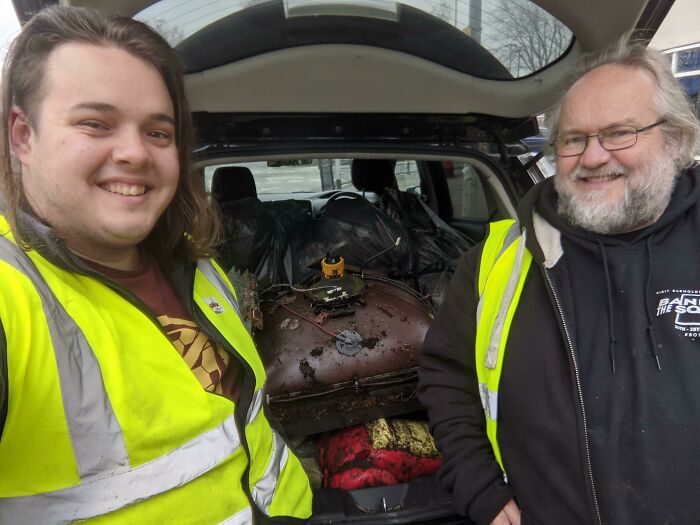 Influencers smiling, with a car trunk full of trash they have removed, advocating against trash taking over the world.
