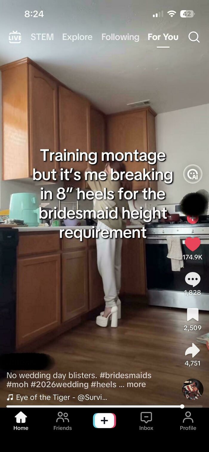 A woman in a kitchen practicing walking in high heels to meet a wedding day height requirement.