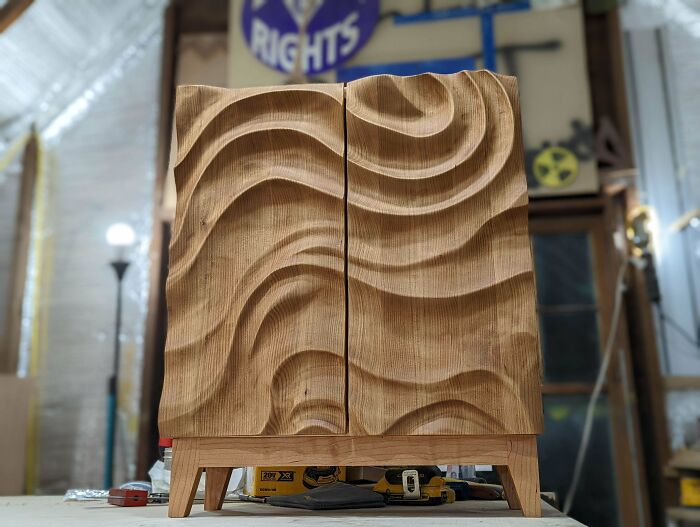 A beautifully carved wooden cabinet, a DIY home project showcasing wavy textures, perfect for transforming a space.