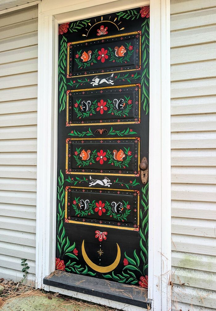 A vibrant black door with colorful DIY home projects including squirrels, rabbits, and flowers, transforming a space.