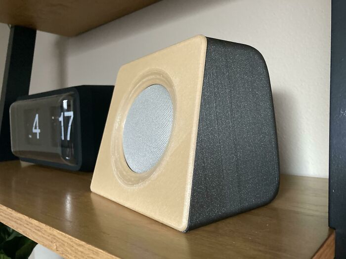 A unique speaker enclosure for a Google Home Mini, crafted using 3D printers with a wood-like finish.