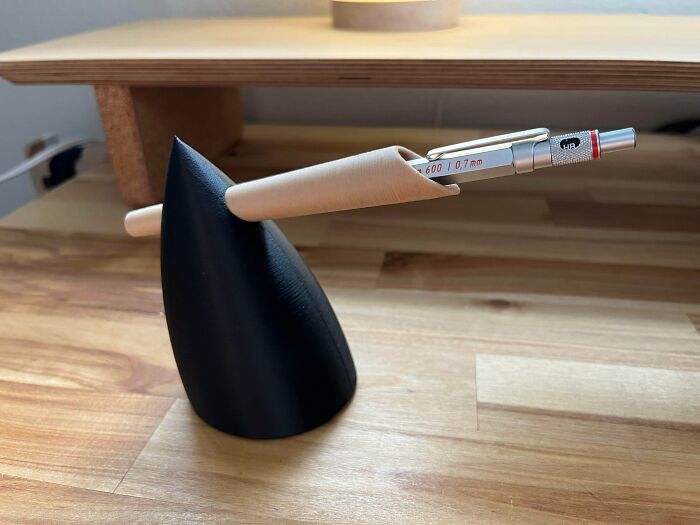 A modern, minimalist 3D printed pen holder in black and wood, a brilliant thing from 3D printers.