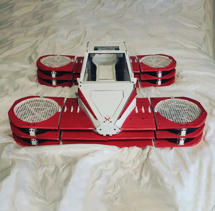A red and white RC hovercraft built with 3D printers rests on a bed, showcasing brilliant things made with 3D printers.
