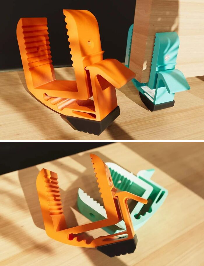 Two orange and teal 3D printer clamps securely hold wooden pieces, showcasing brilliant things made with 3D printers.