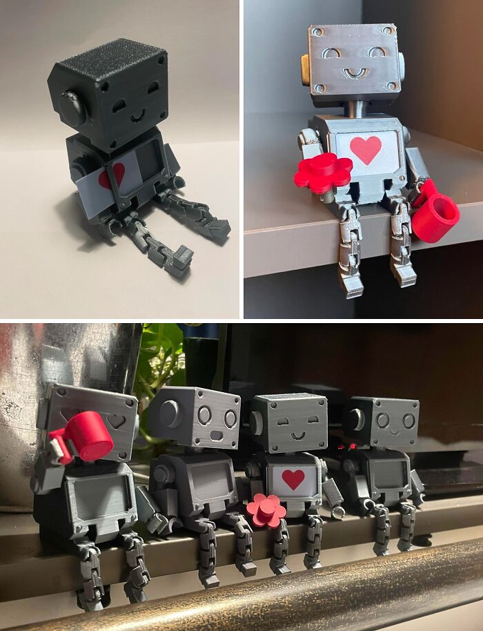 A collection of small grey robot figurines with hearts, crafted using 3D printers, displaying brilliant things.