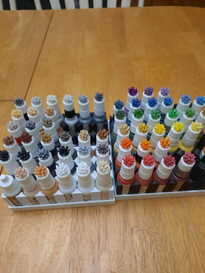 Two holders filled with various colored paints, displaying organized brilliant things made with 3D printers.