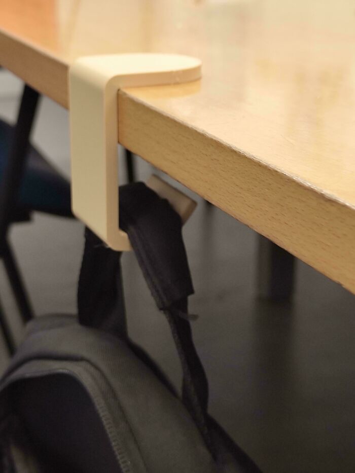 A practical bag hook 3D printed and attached to a wooden table, demonstrating brilliant things from 3D printers.