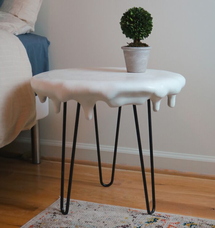 A white side table with a melting effect top and black hairpin legs, a brilliant thing made with 3D printers.