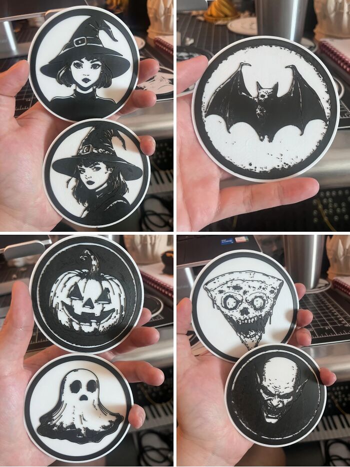 Various Halloween-themed coasters with witches, a bat, pumpkin, ghost, and zombie created with 3D printers.