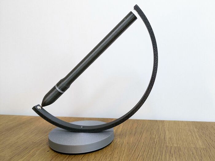 A 3D printed pen stand in black and gray, designed brilliantly to hold a stylus at an angle.