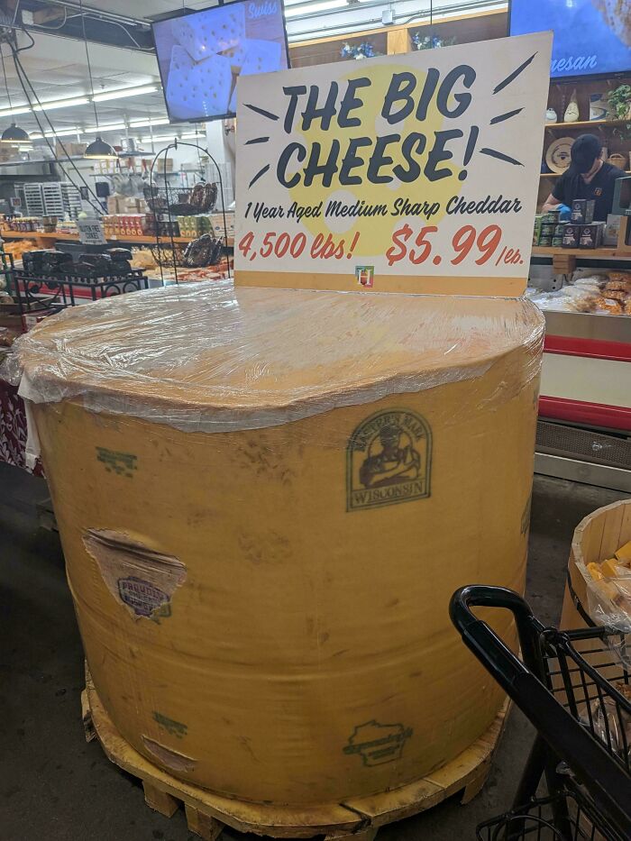 Wild pictures: A giant cheese wheel labeled The Big Cheese in a store, a wonderful and unusual sight in the world.