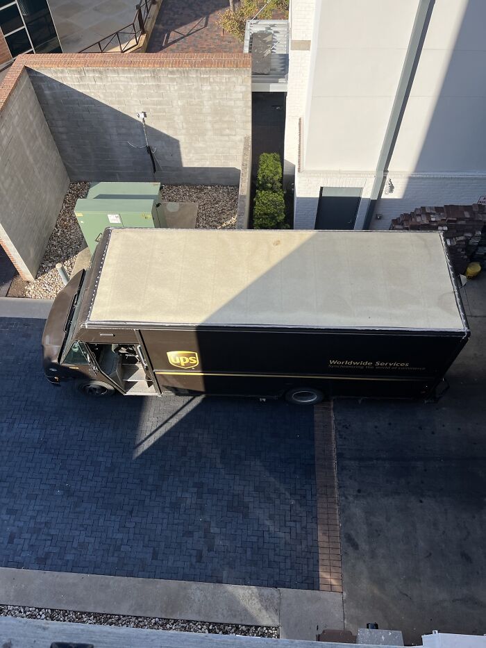 An aerial view of a UPS truck parked in a narrow alley, a wild picture that makes you appreciate the weird and wonderful world.