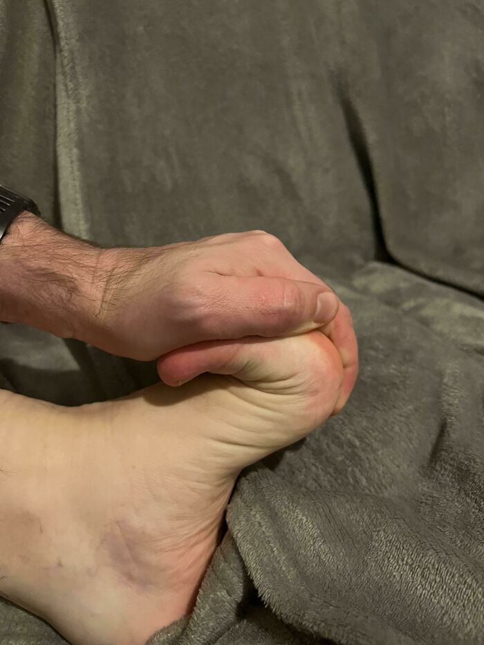 A hand grabbing a foot, demonstrating the weird and wonderful flexibility of the human body.