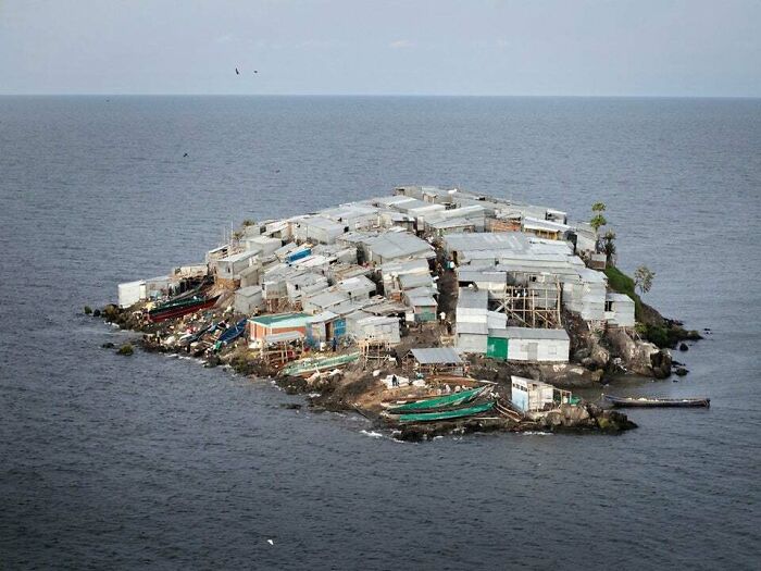 An aerial view of a small, densely populated island covered with shacks and boats, a weird and wonderful part of the world.