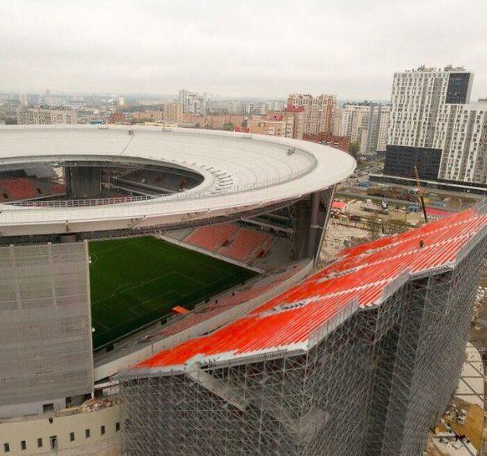 An aerial view of a large stadium under construction, with a city skyline in the background, a wonderful sight.