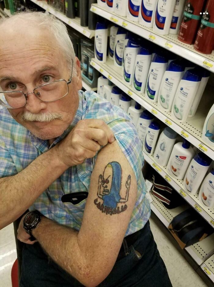An older man showing a unique arm tattoo, a weird and wonderful picture.