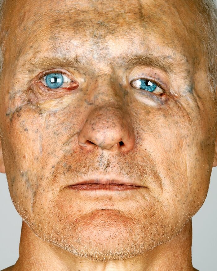 An intimate portrait by Brock Elbank of an older man with striking blue eyes, revealing his unique facial stories.