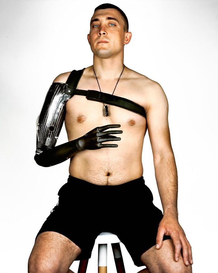 A portrait by Brock Elbank of a man with a prosthetic arm, highlighting the unique stories behind the faces.