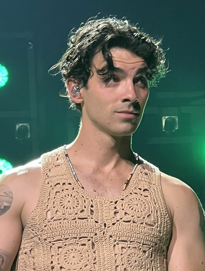 Joe Jonas on stage, headshot highlighting his curly hair and expressive face, showcasing his career highlights.