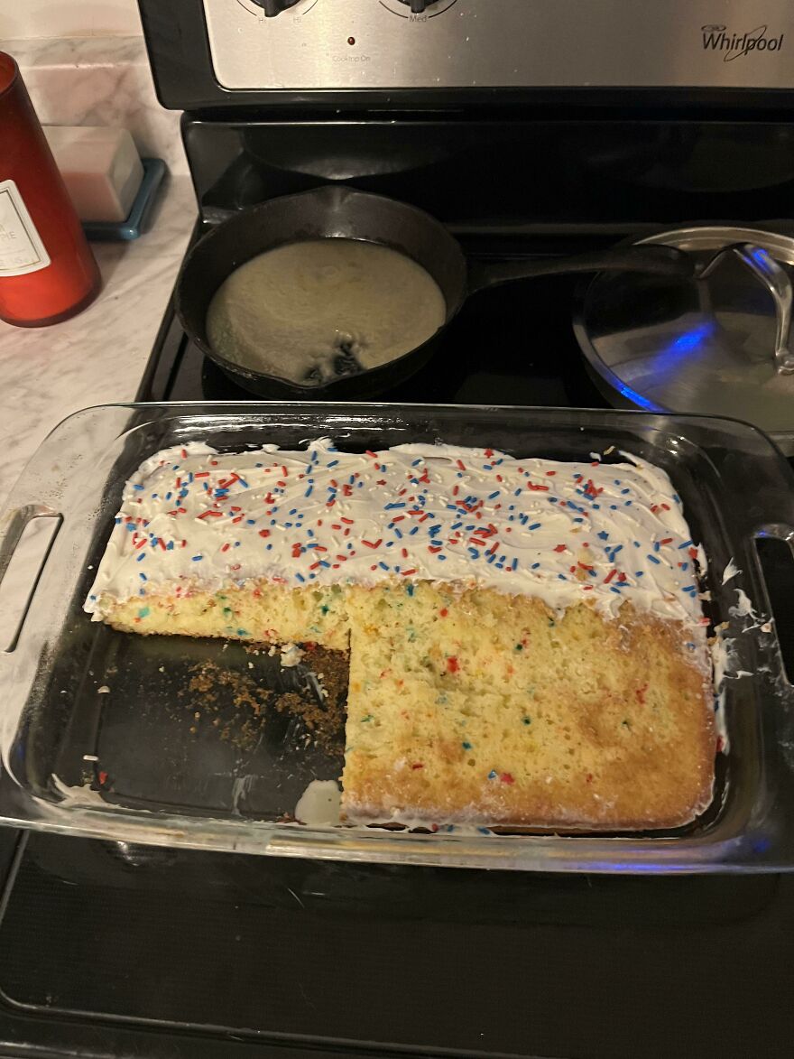 A cake with a large, funny fail-cut piece missing, showing sprinkles on top and a messy slice.