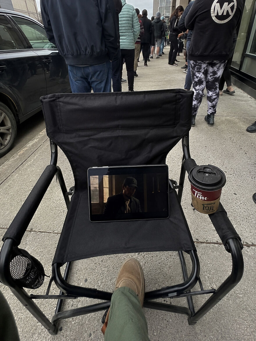 A person watching a movie on a tablet in a folding chair, an example of how people manage their side hustles.
