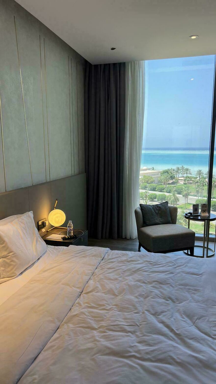 A modern hotel room with a stunning ocean view, symbolizing the freedom a successful side hustle can provide.