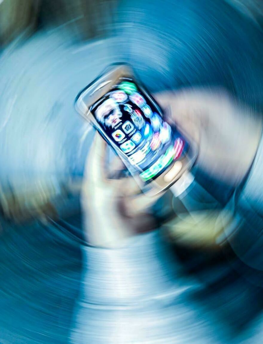 A person holds a smartphone with app icons in a motion blur effect, representing a digital side hustle.