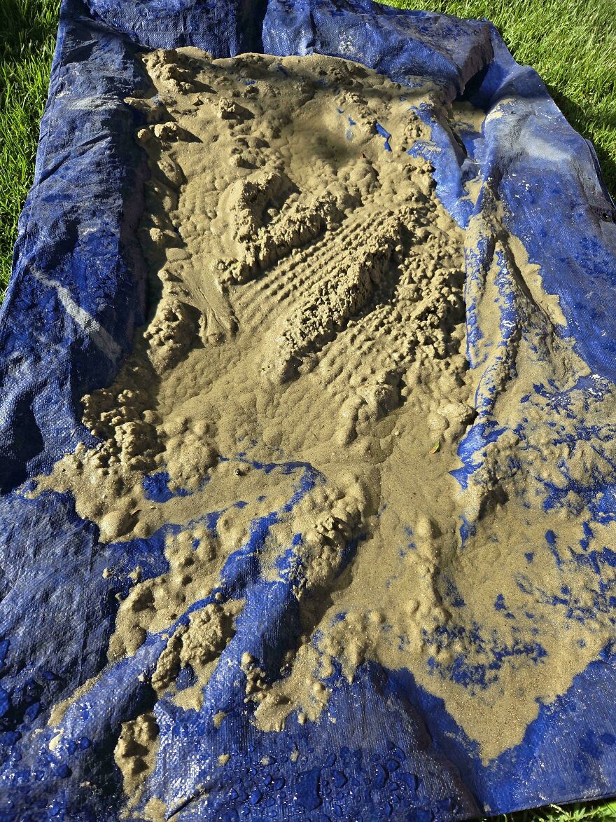 A blue tarp with a large pile of sand on it, an unfortunate fails moment.