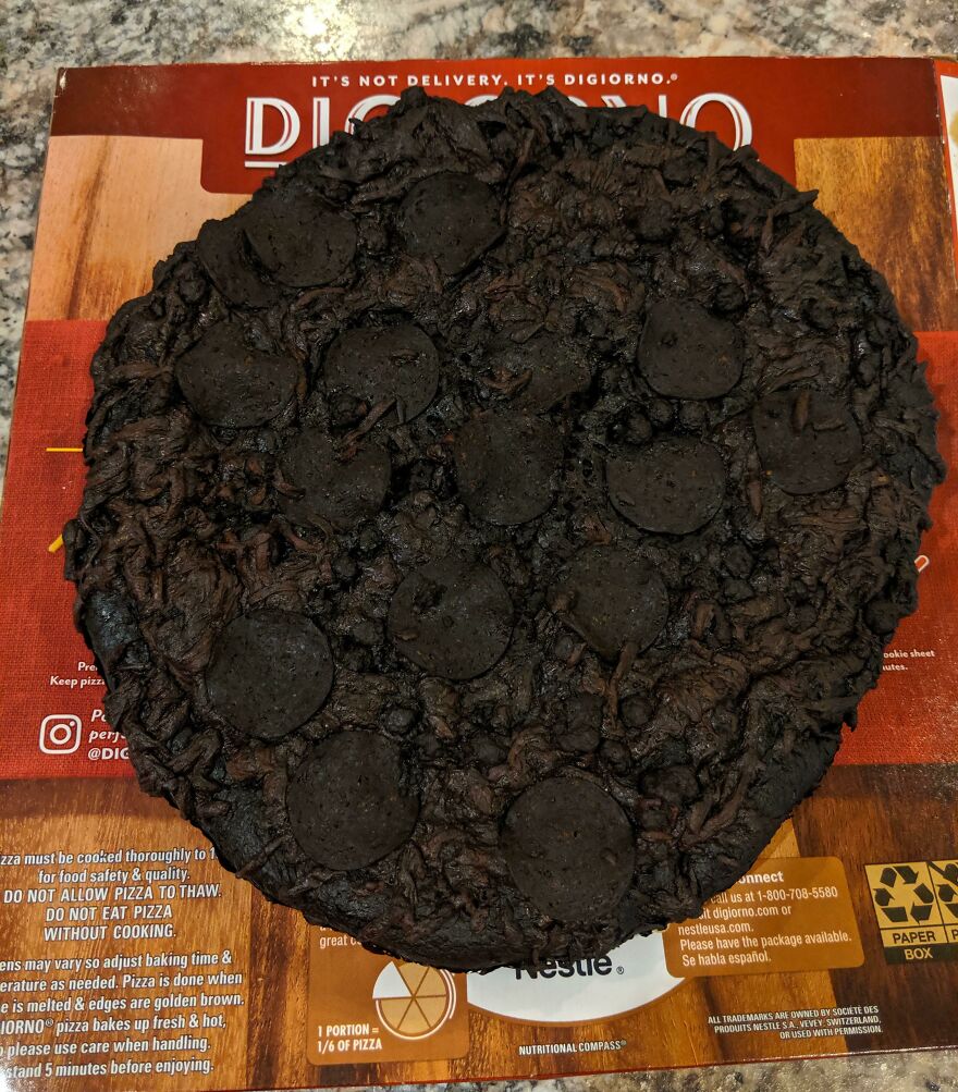 A completely burnt and black pizza on top of its Digiorno box, a funny fails moment.