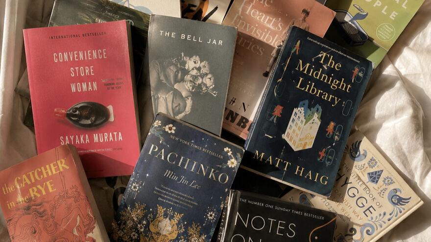 A pile of various books, highlighting how a weird side hustle can involve reading to make extra dough.