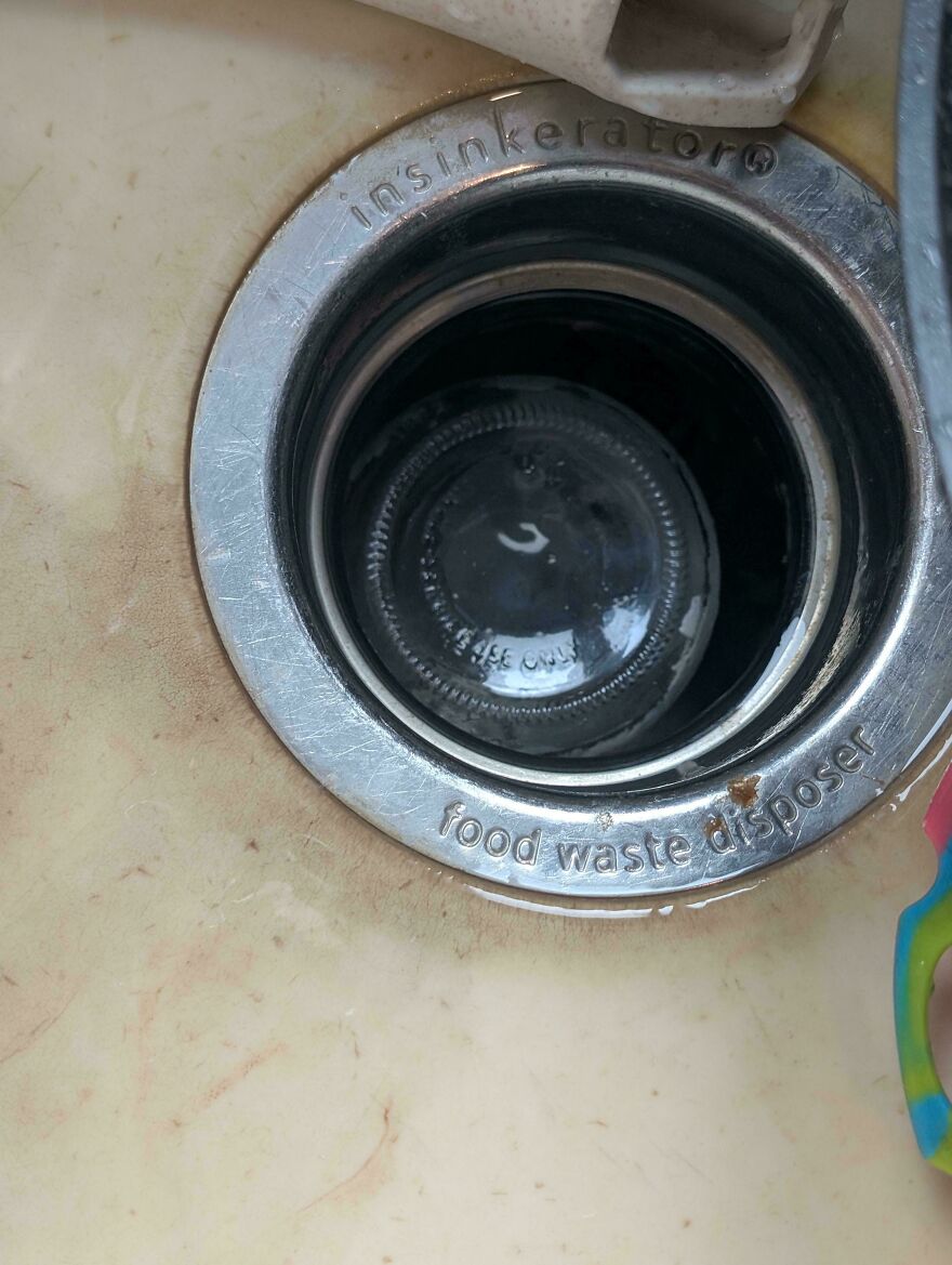 A glass bottle stuck in a food waste disposer, an unfortunate fail and funny regret.