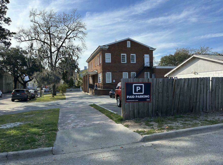 A Paid Parking sign in front of a building, illustrating a property-based side hustle.