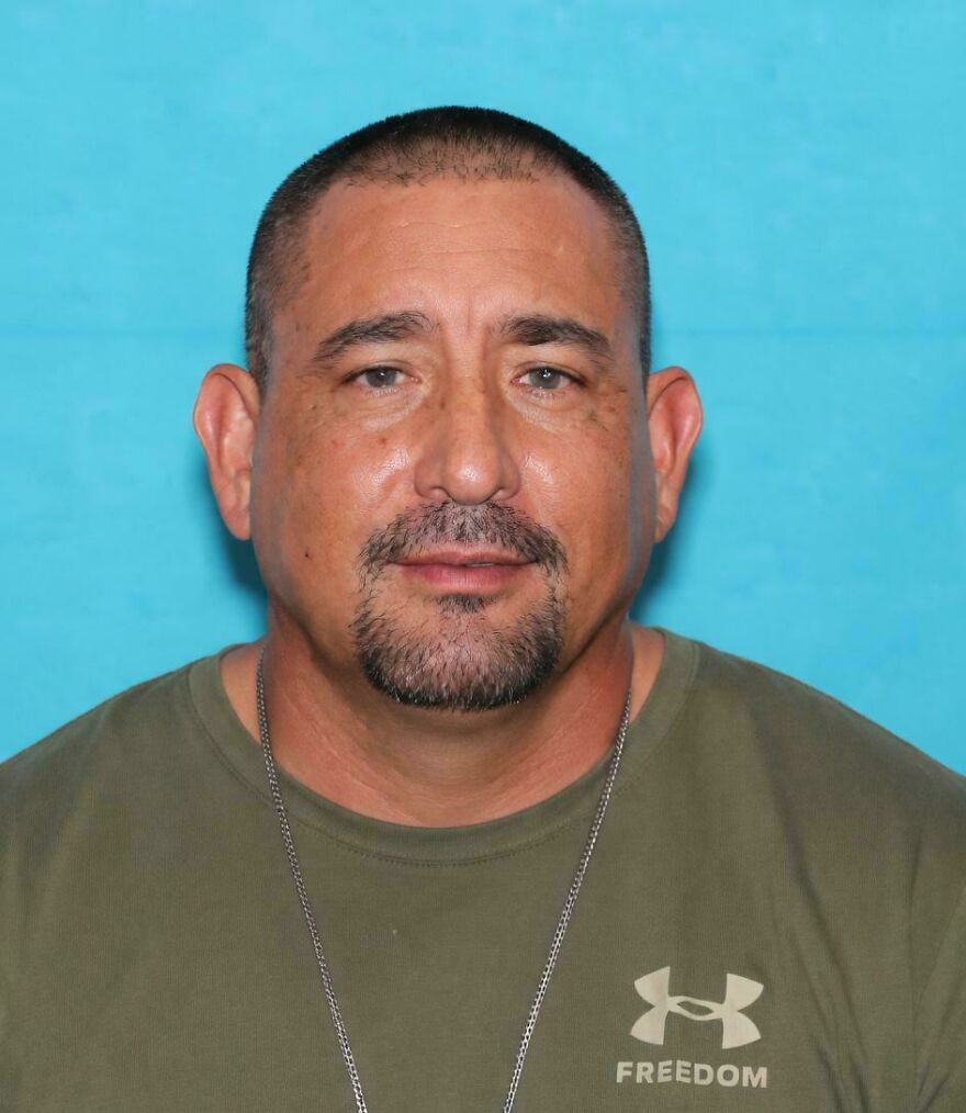 A mugshot-style photo of a man with a goatee and a green t-shirt, one of the strange things happening on Earth.