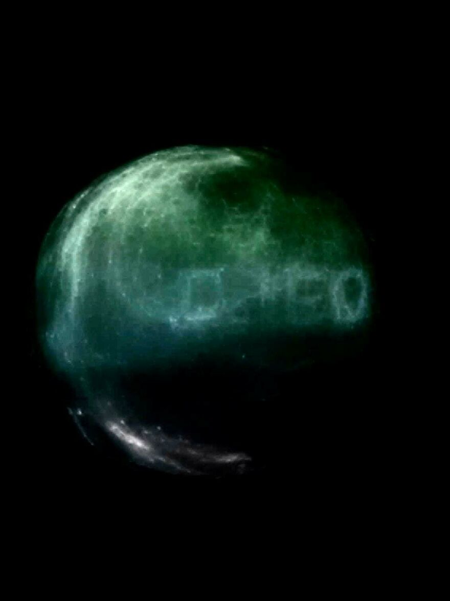 A strange green glowing orb with a word-like pattern against a dark background, one of many incredible things happening on Earth.