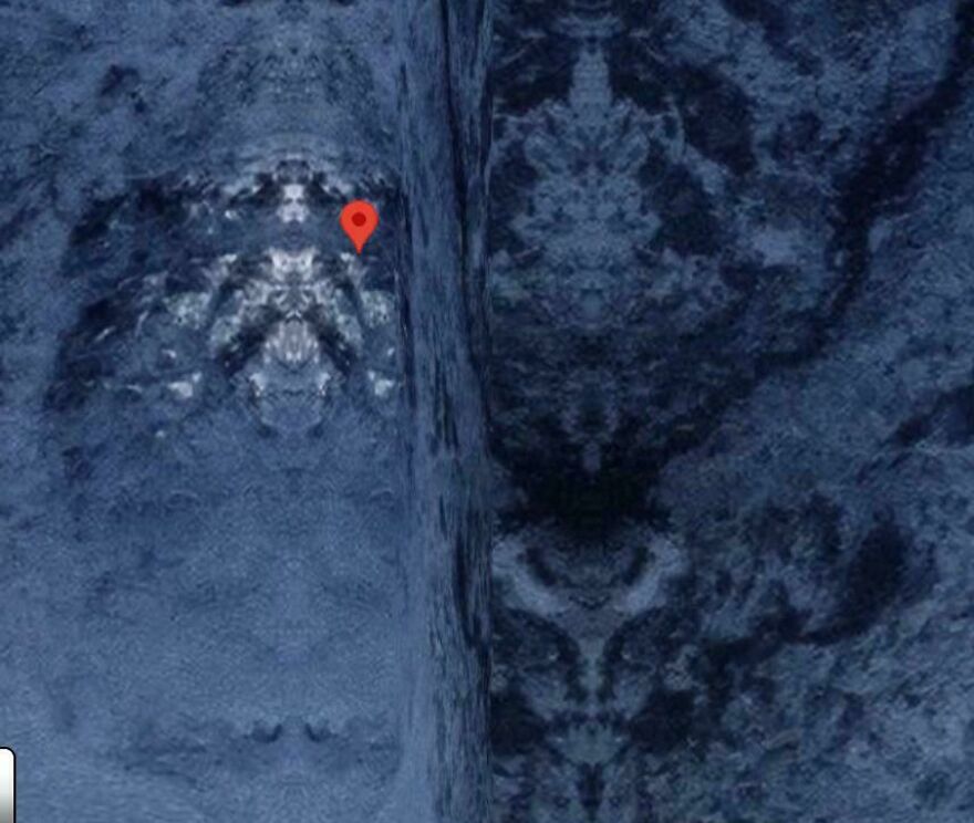 Strange thing happening on Earth: A map pin marking a location on a textured, possibly icy, dark blue surface.